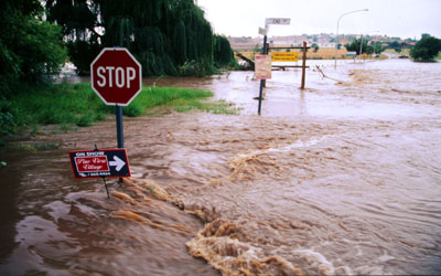 Heavy flooding during rainy season caused by channeling of river and urban development in watershed. 